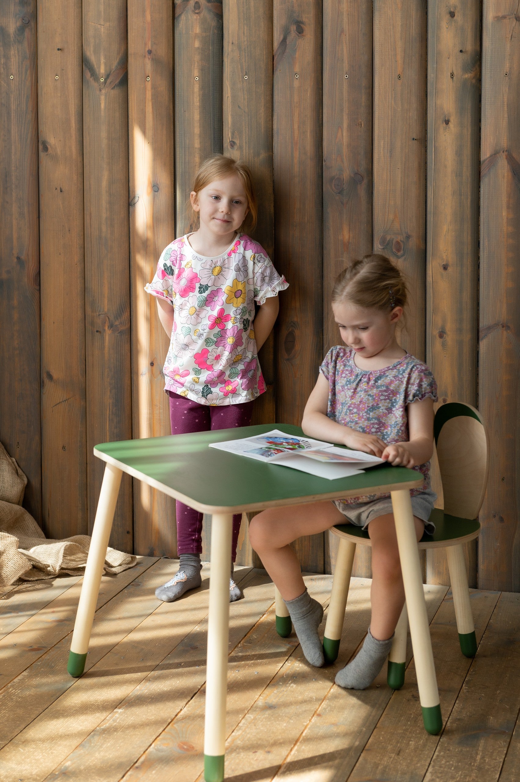 a child's hands drawing at the birch plywood bunny table set in a cozy nursery corner