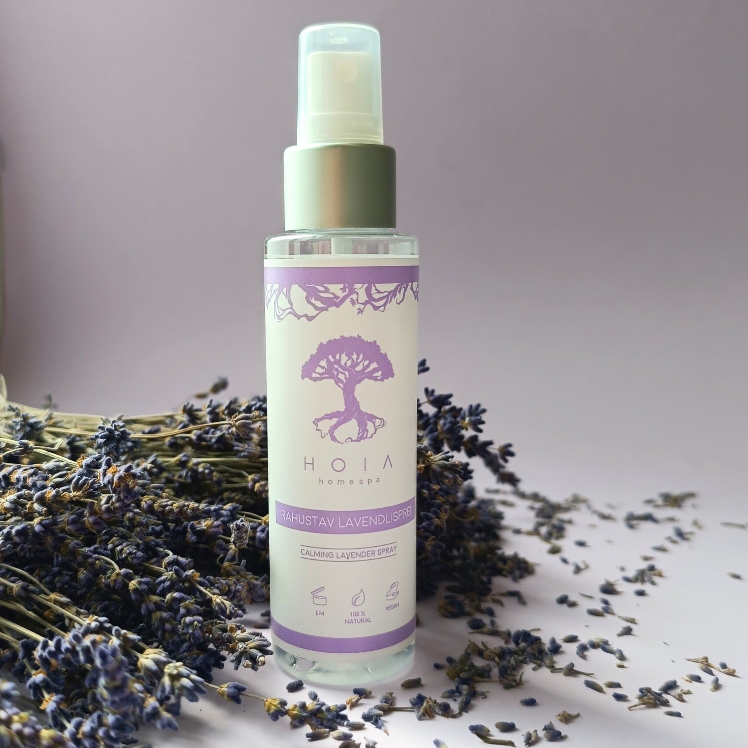 bold close-up of a 100ml lavender spray bottle with a dramatic mist against a dark background