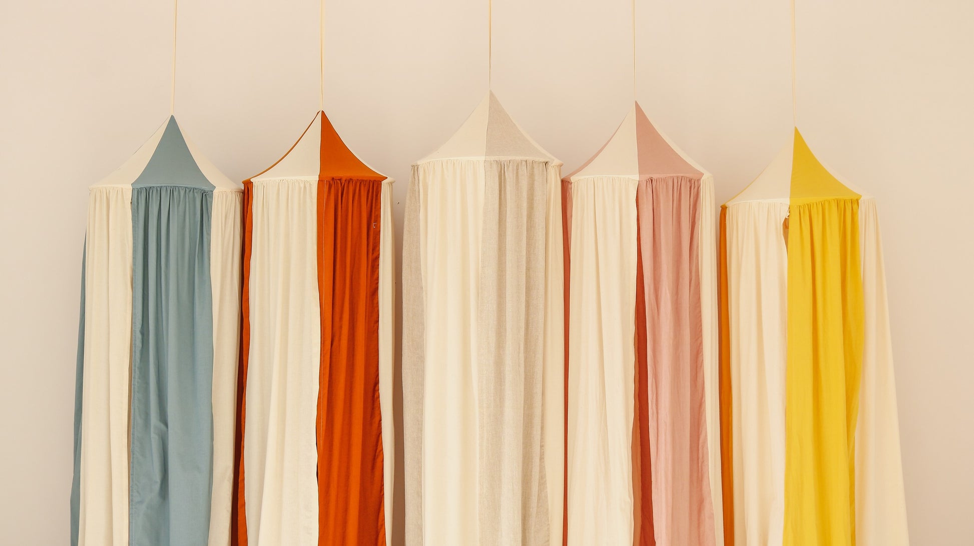 a playful blue circus canopy hung over a child's bed with soft toys peeking out from underneath