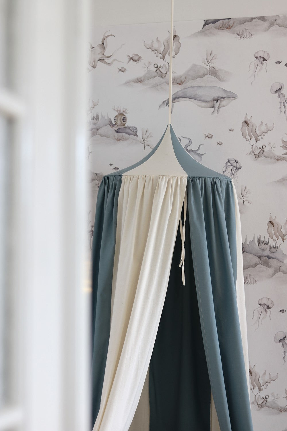 blue circus canopy showing practical hanging loop and textile texture on a neutral wall
