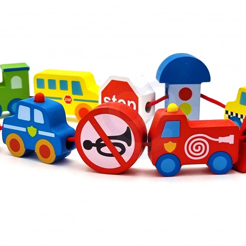 a child's hand playfully threading a vibrant wooden tractor block onto a string