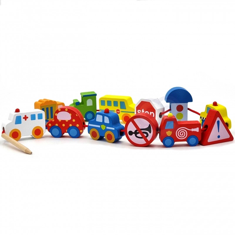 a child's small hands threading a wooden tractor block onto a green string