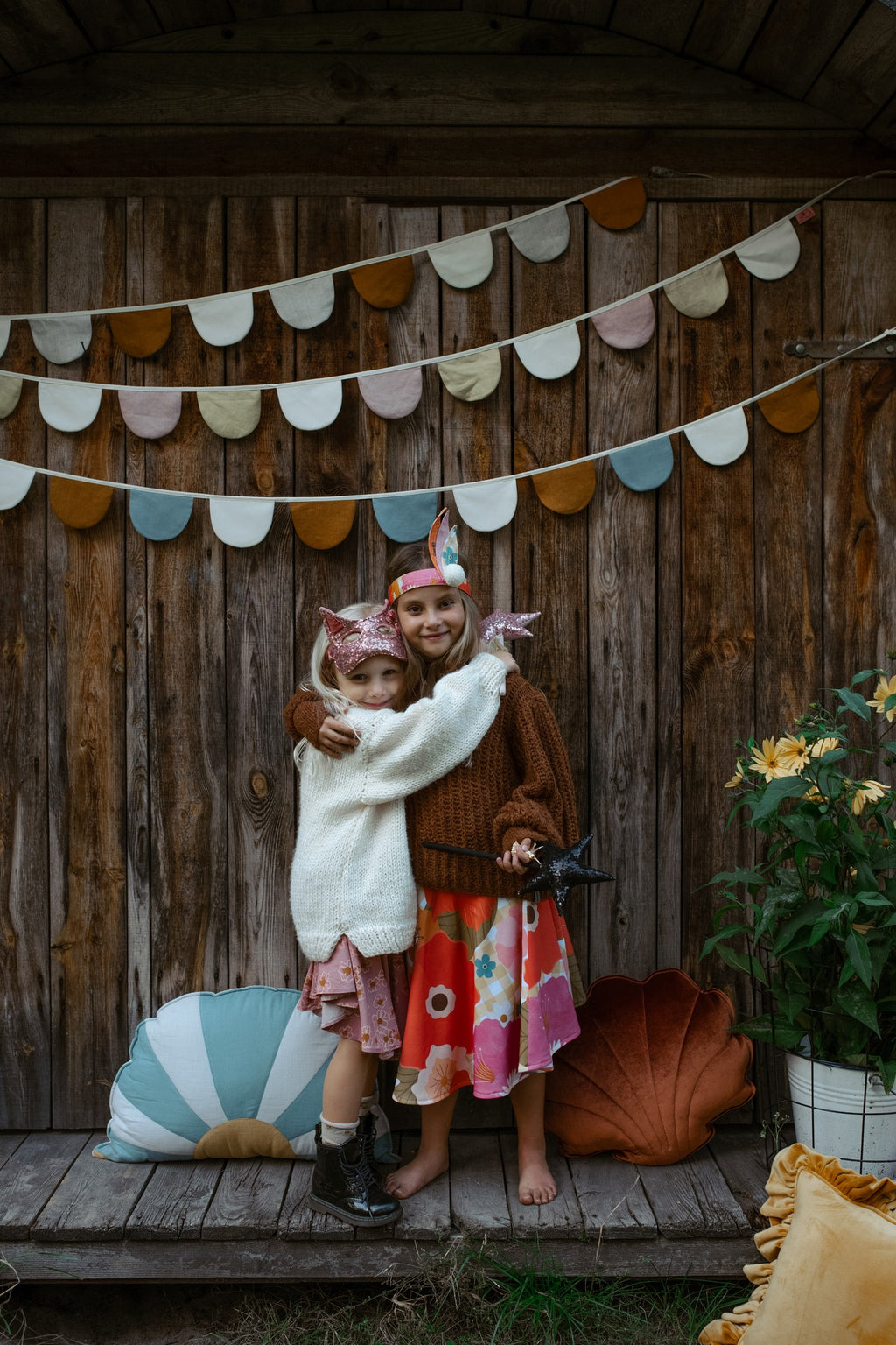 a playful child wearing a glittery gold cat mask, laughing during a sunny afternoon playdate