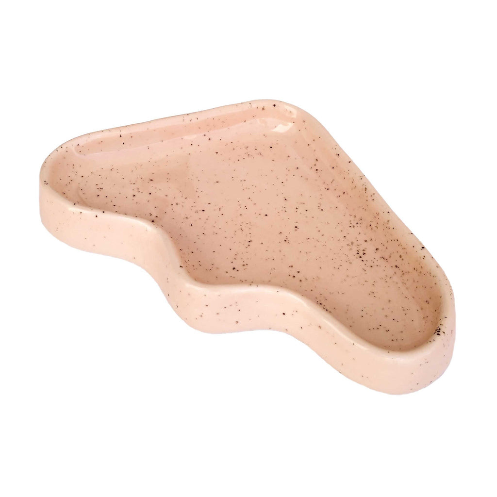 speckled peach ceramic wave tray on a wooden table, holding keys and coins, practical and stylish