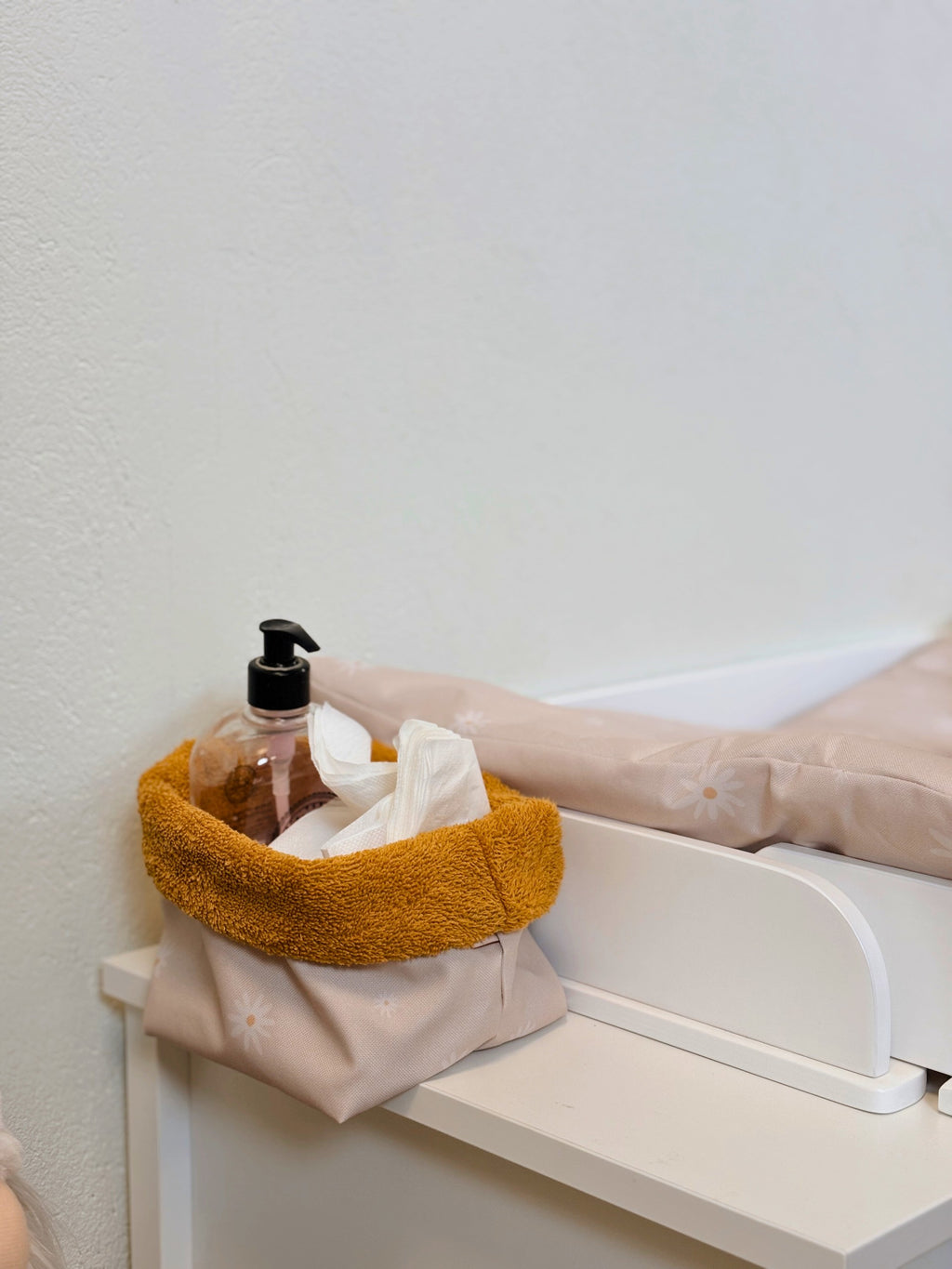 a soft-lit nursery with a compact latvia-made storage basket holding baby essentials