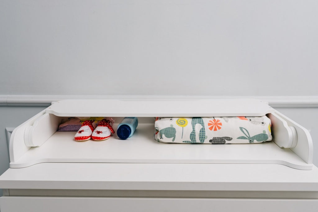 playful birch changing table top on a colorful nursery dresser