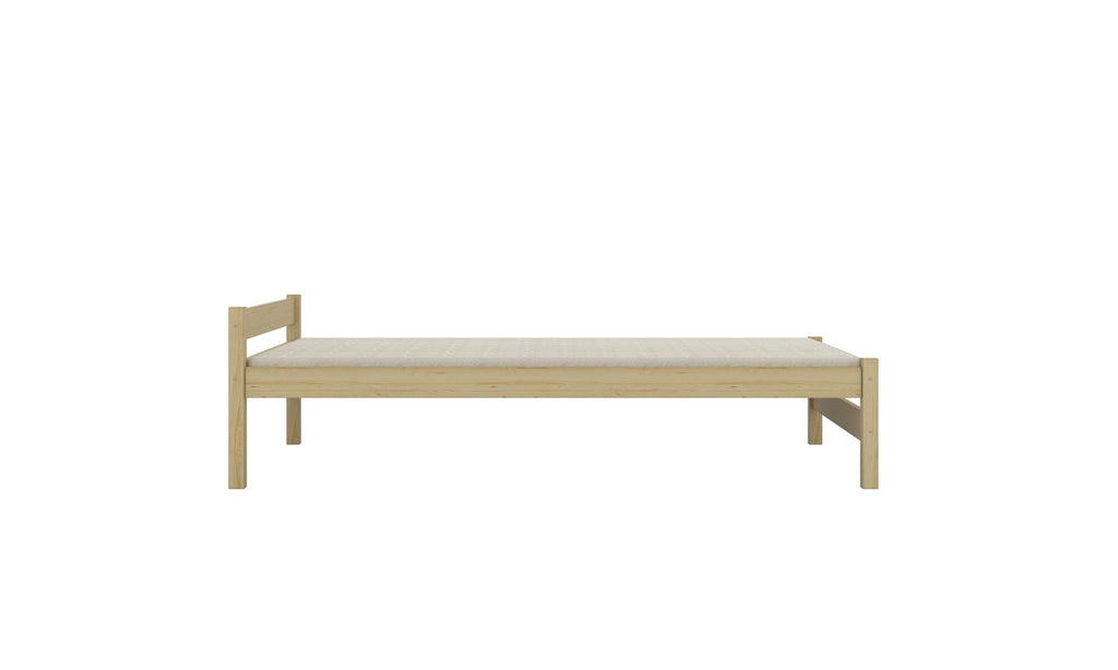 soft morning light on a natural pine wood childrens bed with a cozy quilt
