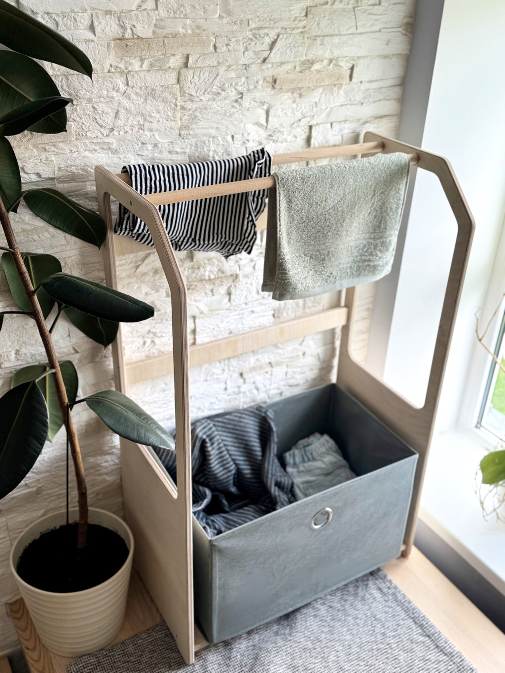 a playful close-up of the kids drying rack with a vibrant green laundry basket full of tiny socks