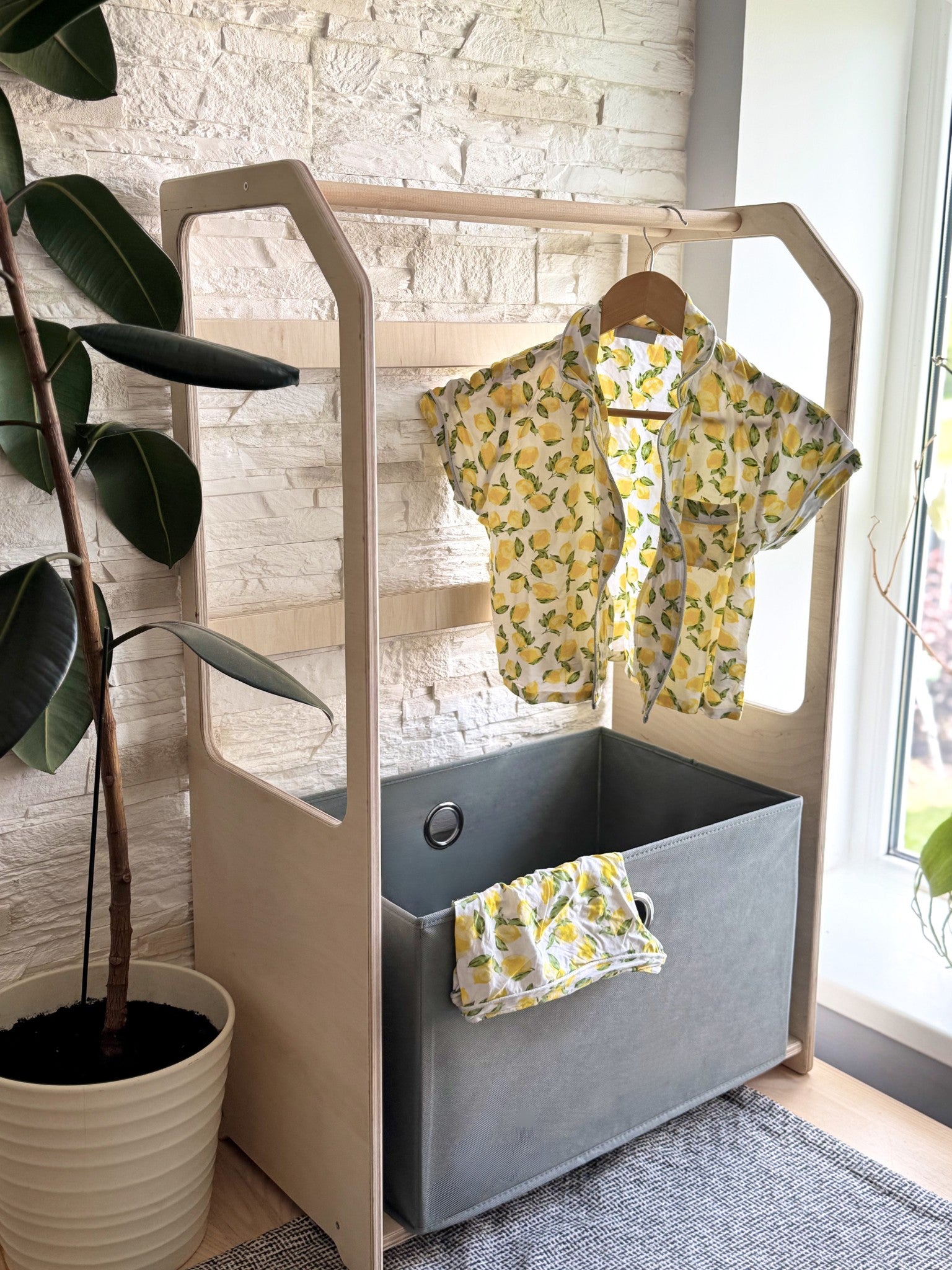 montessori drying rack with green laundry basket in a bright playroom setting