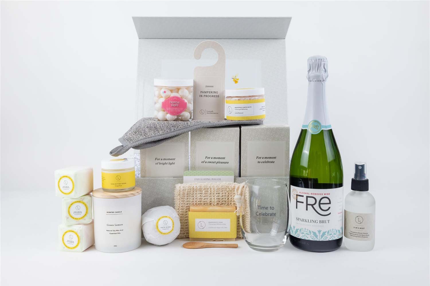 confident display of a celebration gift box with bottle, candle, and grapefruit bath essentials