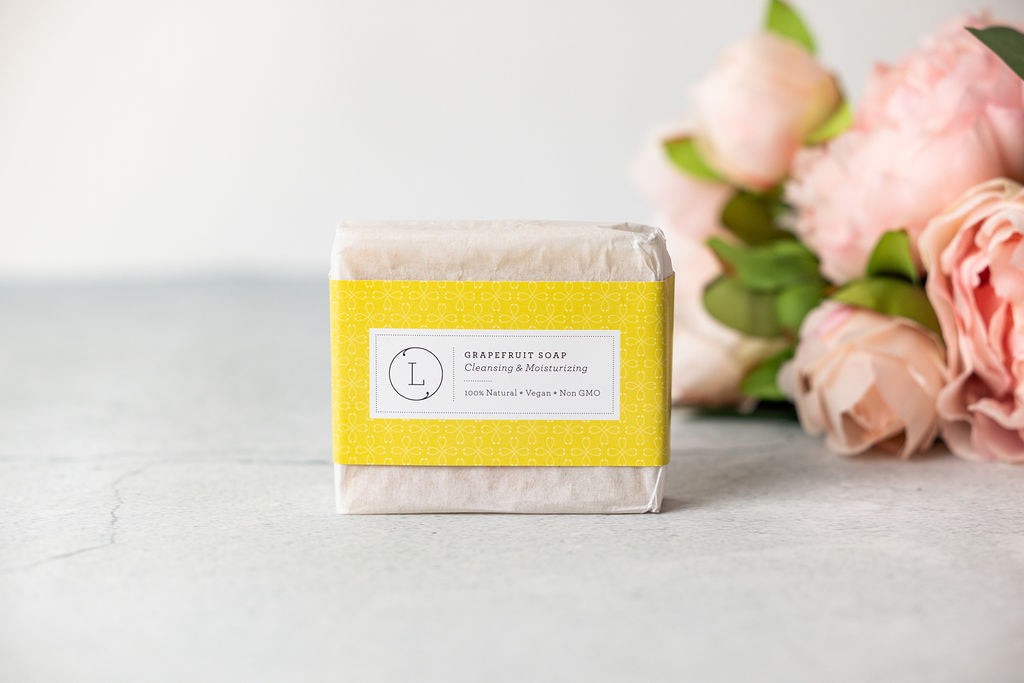 elegant celebration gift box with grapefruit bath bomb and plush gray towel artfully arranged