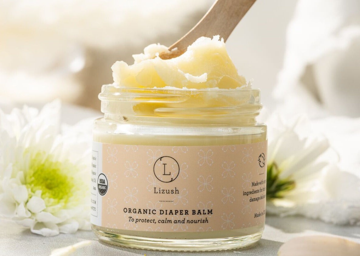 practical layout of organic baby gift set contents - balm, powder, and bib on a clean surface