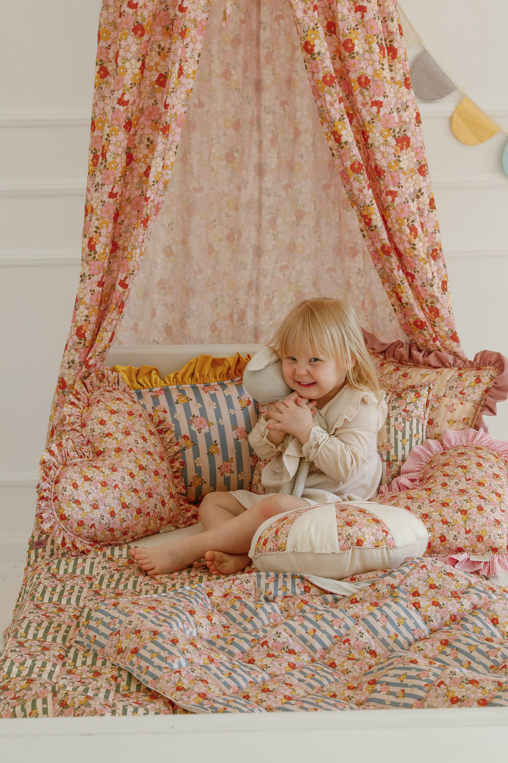 functional green garden cotton quilted blanket and pillow set laid flat on a wooden floor, showcasing patchwork details