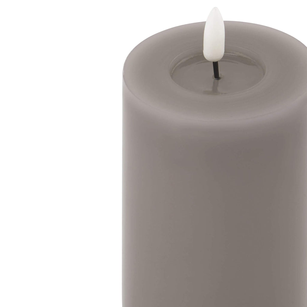 softly glowing grey led candle with a gentle melt effect, casting a warm comforting light in a cozy room