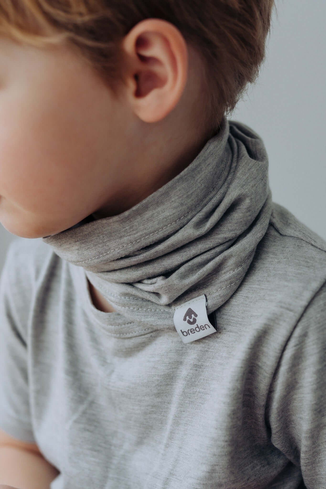 bold close-up of a kid's sustainable bamboo tube-scarf in summer sunlight