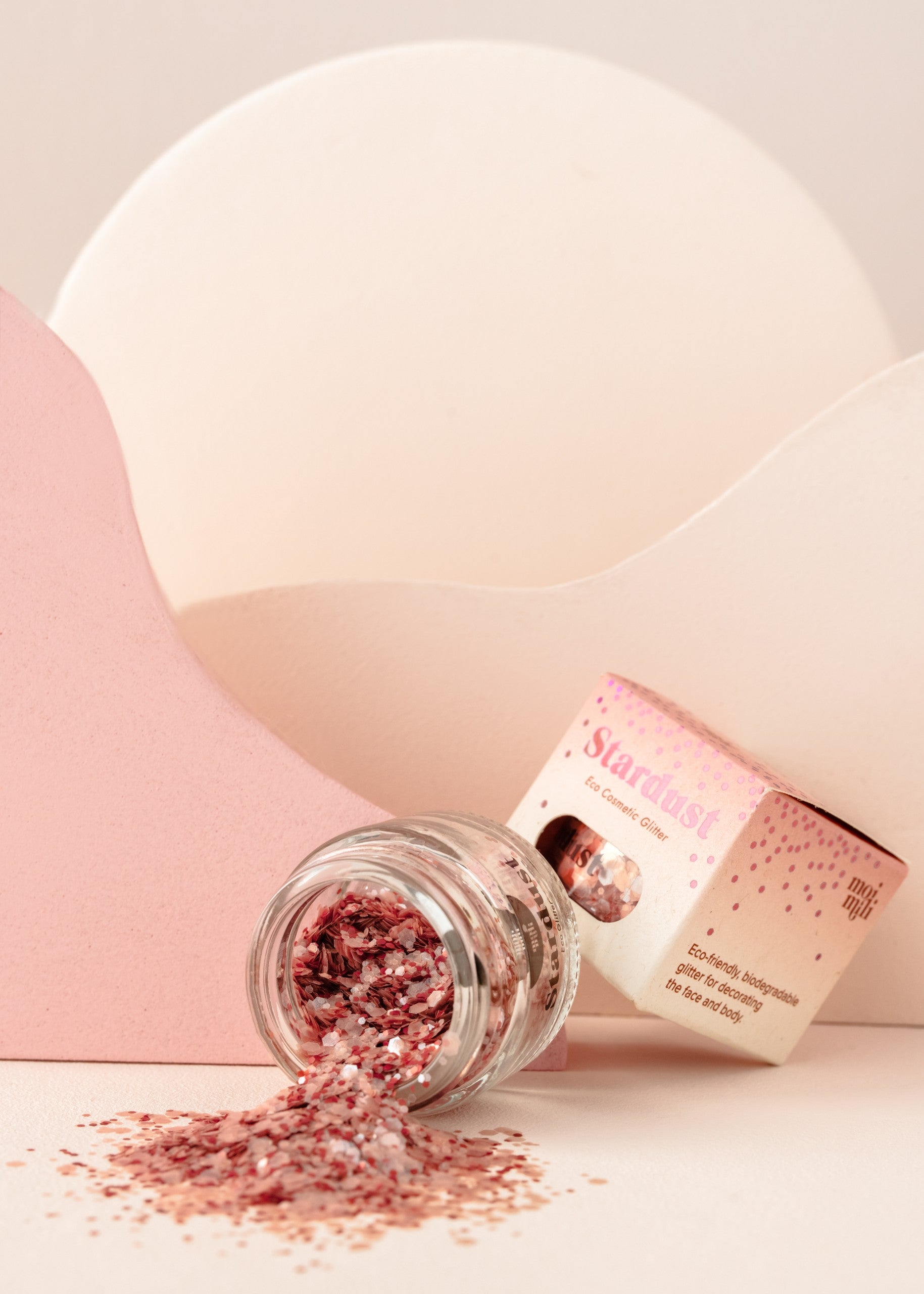 playful pink star dust glitter being sprinkled from fingers onto a sunny surface