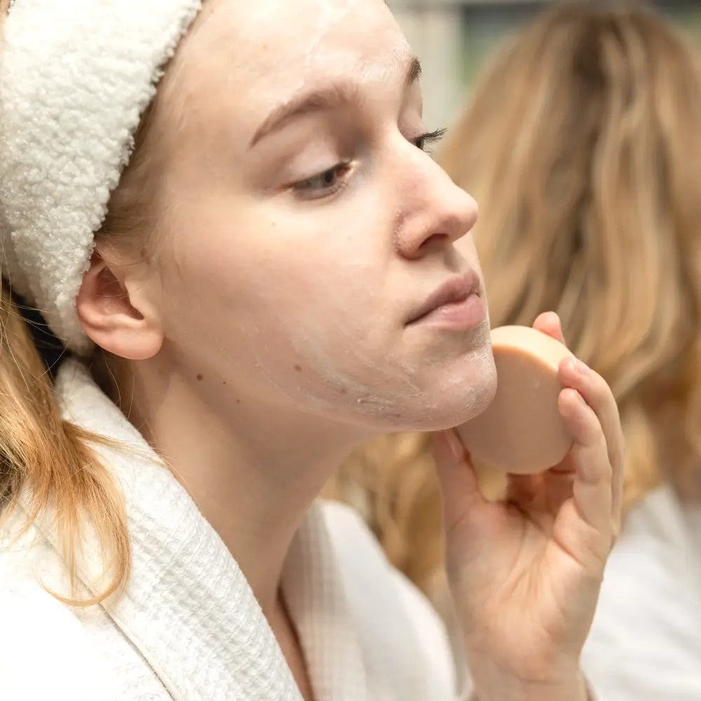 pink clay face cleanser bar on a wooden tray with natural light, showcasing its vegan and cruelty-free formula