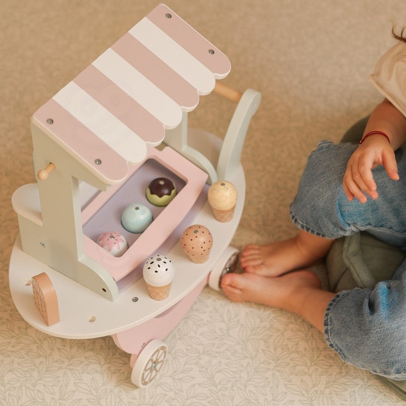 a child's hands holding a magnetic ice cream scoop from the woopie green pastel cart
