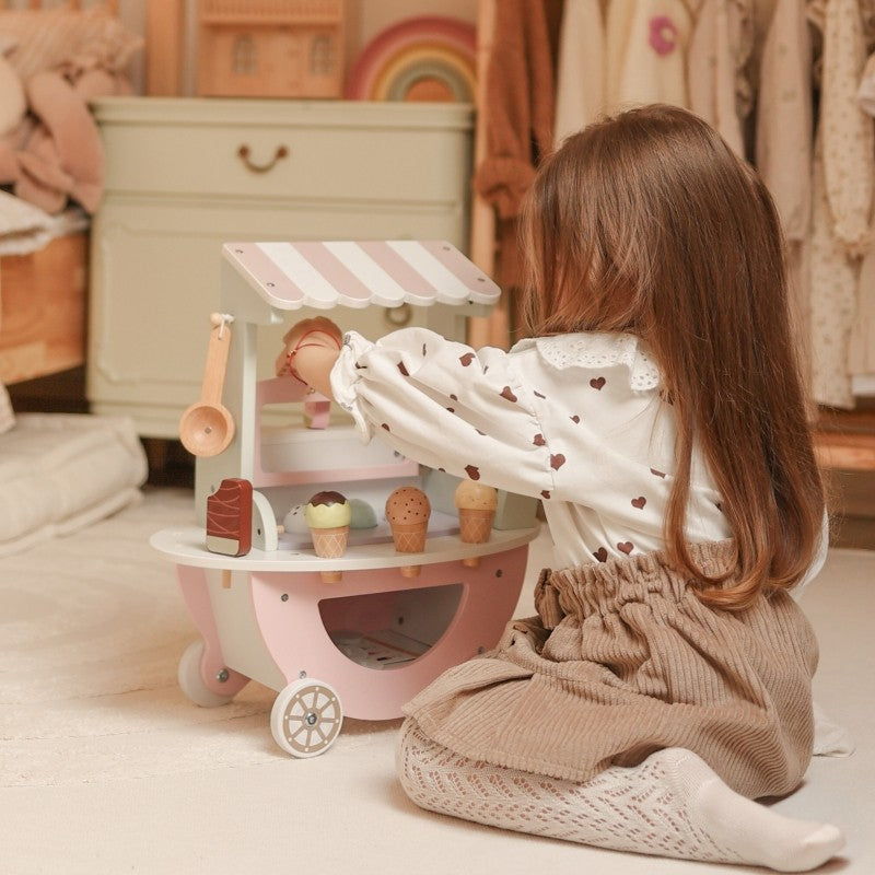 child's hand holding a magnetic pastel ice cream scoop from the woopie green cart