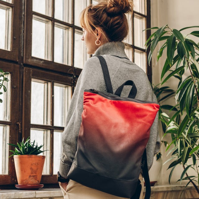 bold salmon faux leather backpack with a striking muni design and grey waterproof base