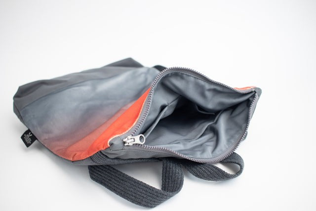 stylish salmon faux leather backpack with a soft velvet top and grey waterproof base, shown in warm natural light