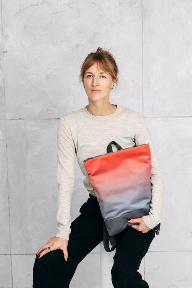 stylish salmon faux leather backpack with a velvet muni design, shown in a warm, inviting light