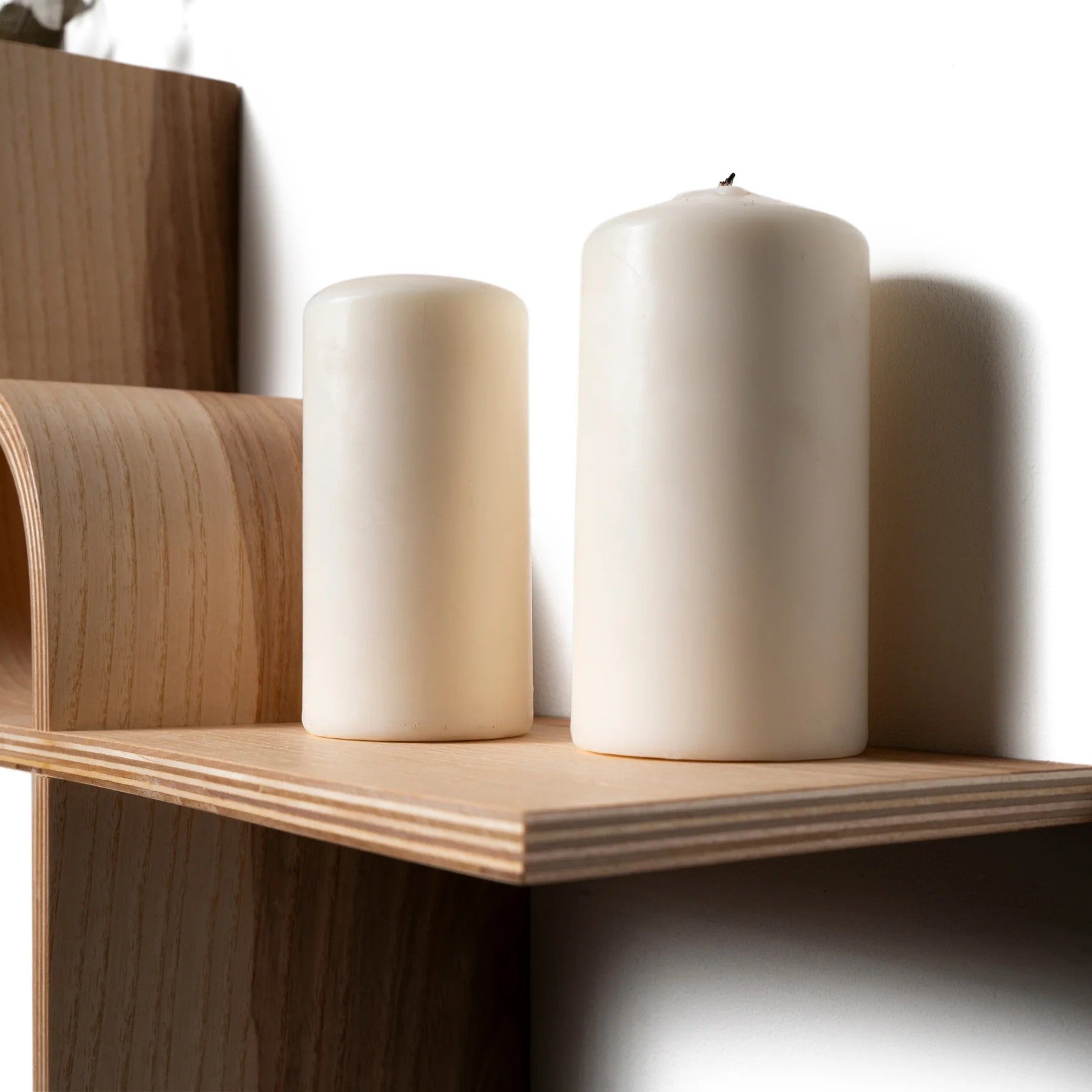 functional floating shelf in ash finish holding a stack of books and a small potted plant