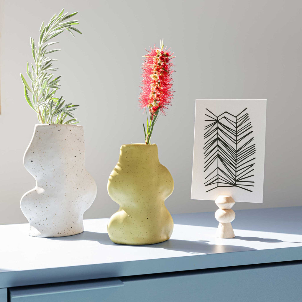a soft, comforting close-up of the handmade white ceramic fluxo vase on a cozy table