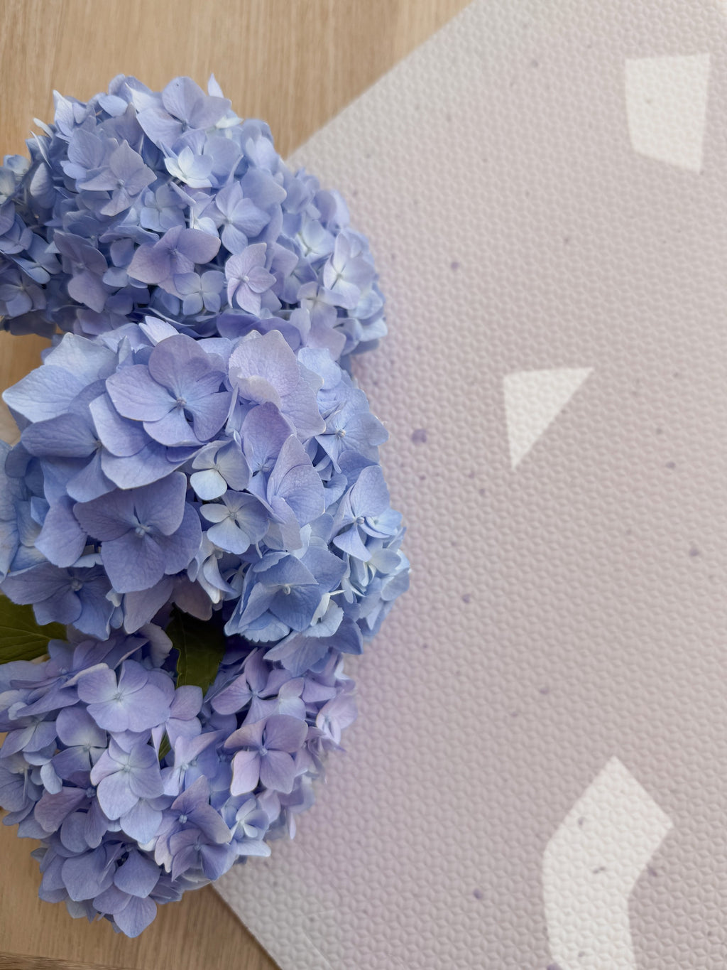 a stylish lavender terrazzo foam playmat for babies, shown in soft morning light on a wooden floor