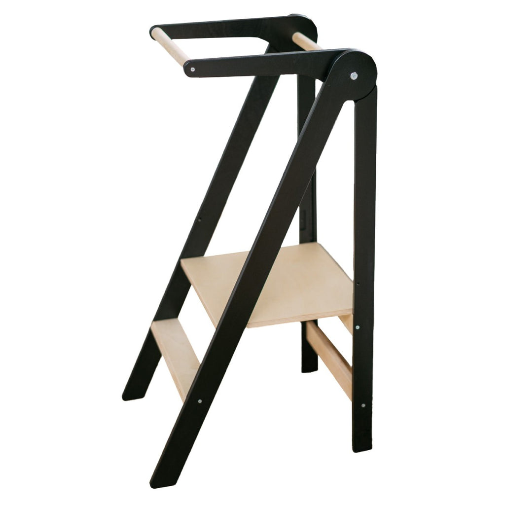 foldable kitchen helper tower in a bright playroom with morning light highlighting the birch wood grain