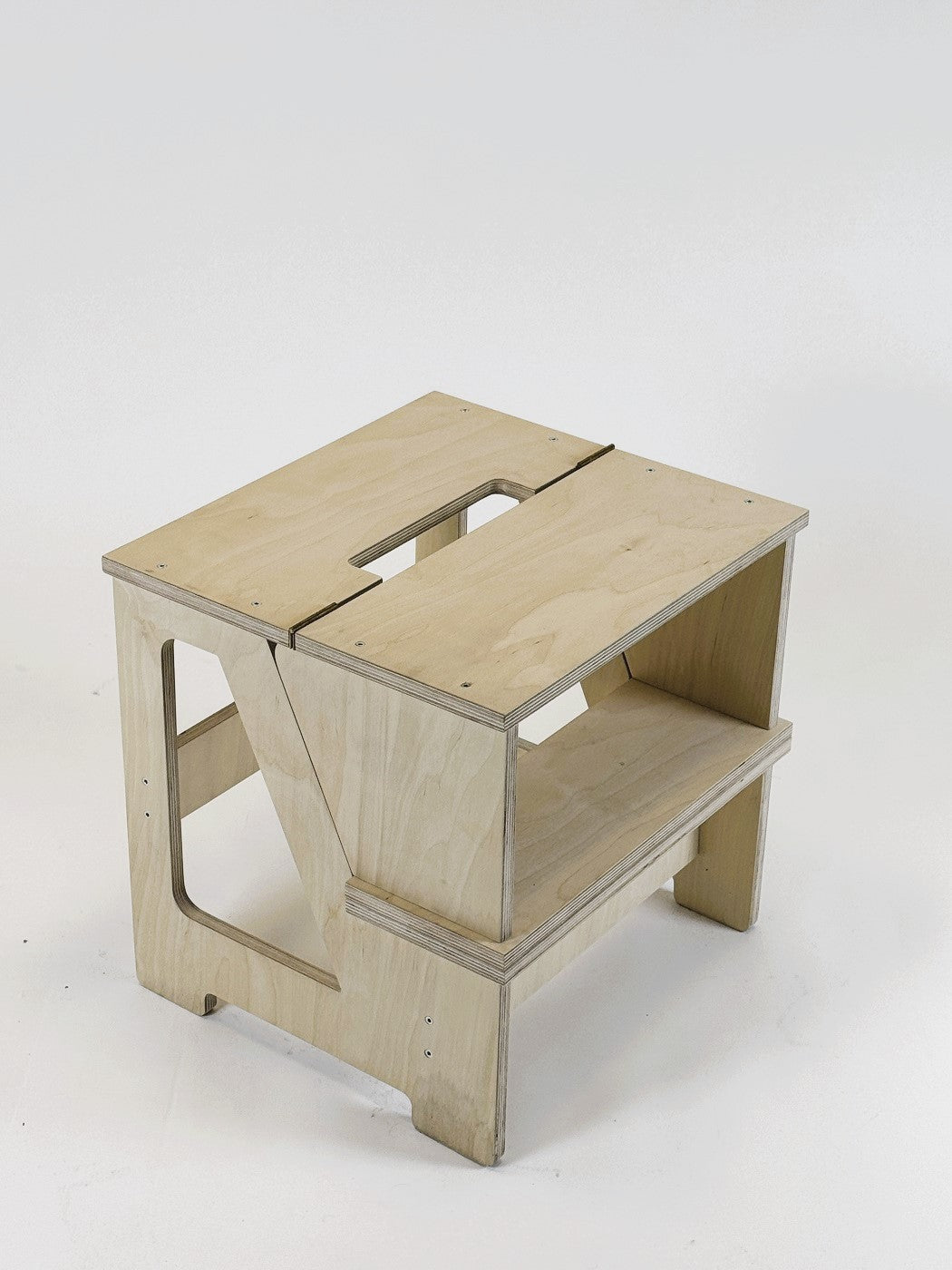 a functional solid wood step stool folded flat against a minimalist wall