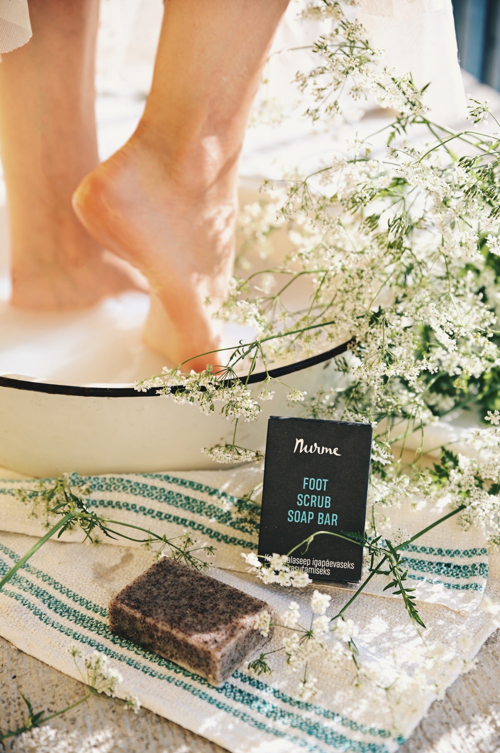 close-up of handcrafted foot scrub soap bar with visible pumice and almond powder exfoliants