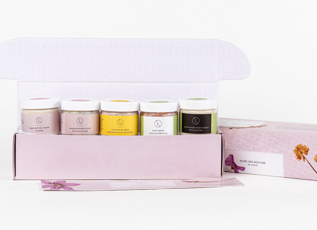 practical layout of a luxury home spa gift set with body scrub, foot cream, and clay mask on a clean surface