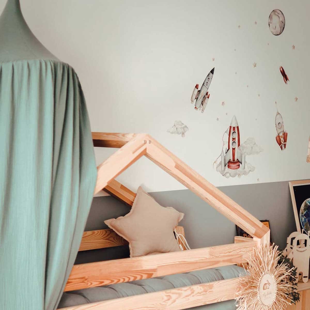 functional kids room with watercolor rocket wall stickers arranged in a practical layout above a bed