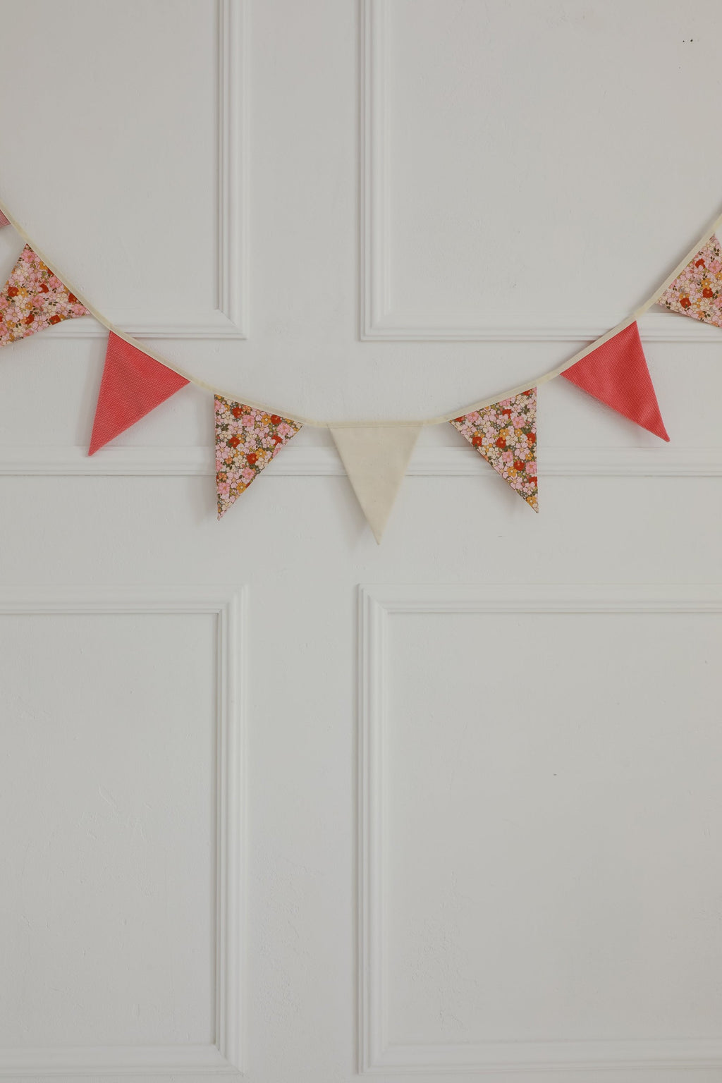 cotton and velvet birthday garland draped over a teepee creating a cozy magical nook