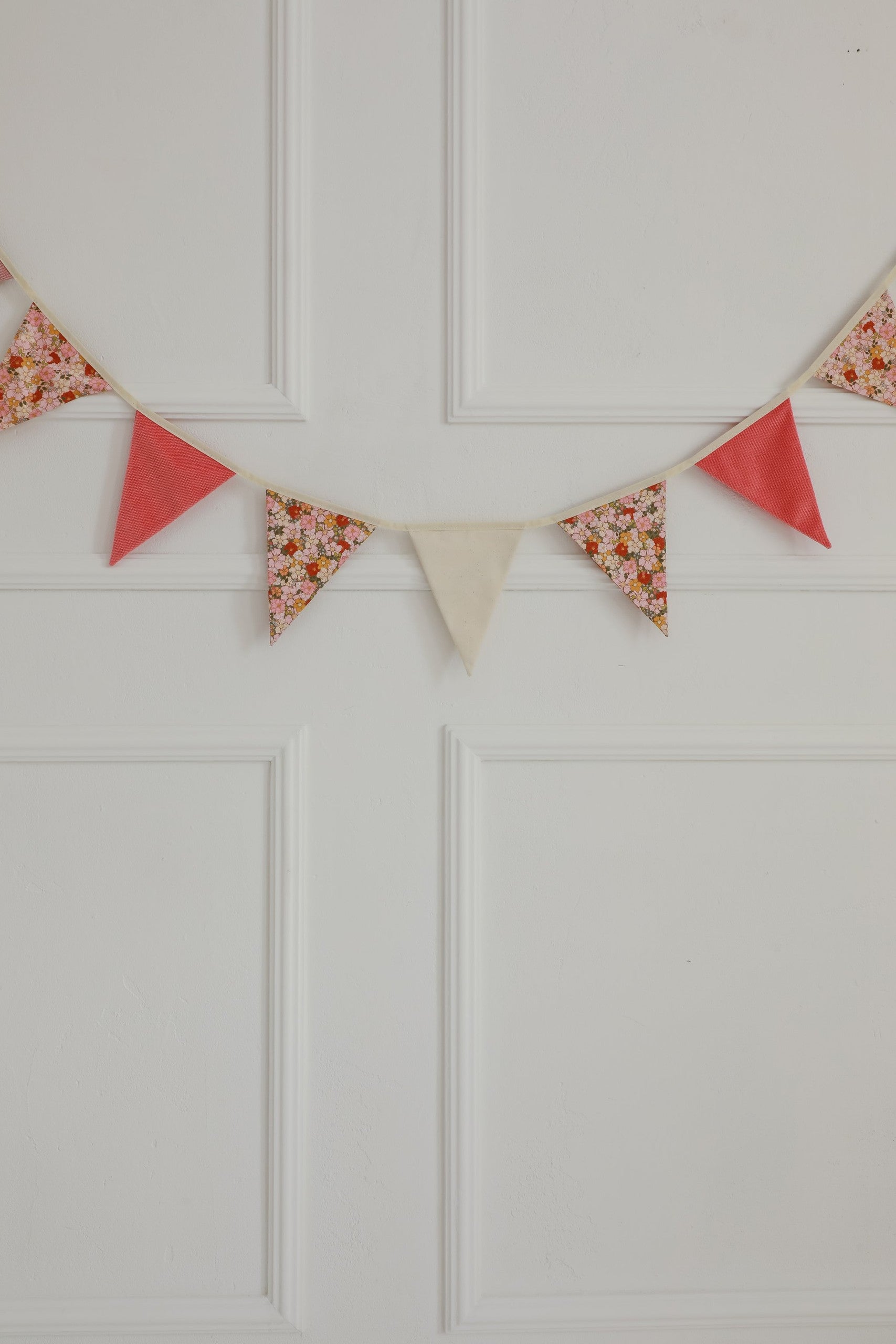 cotton and velvet birthday garland draped over a teepee creating a cozy magical nook