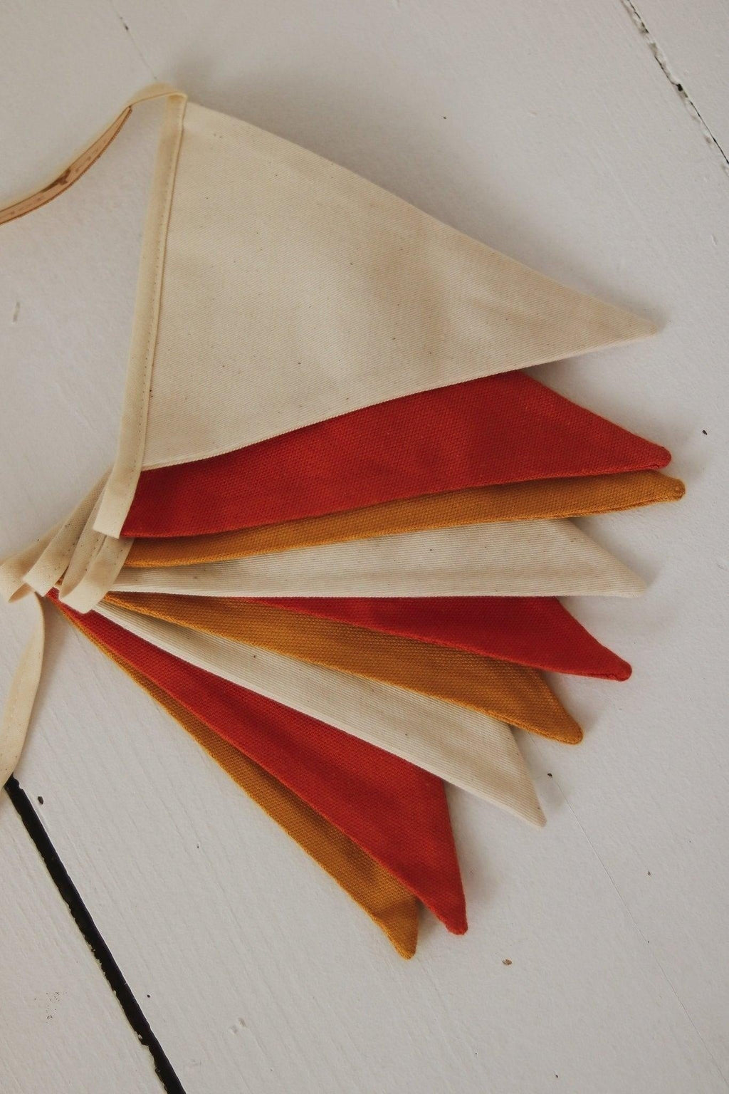 soft ochre floral garland with cotton pennants in warm, gentle light for a child's cozy room