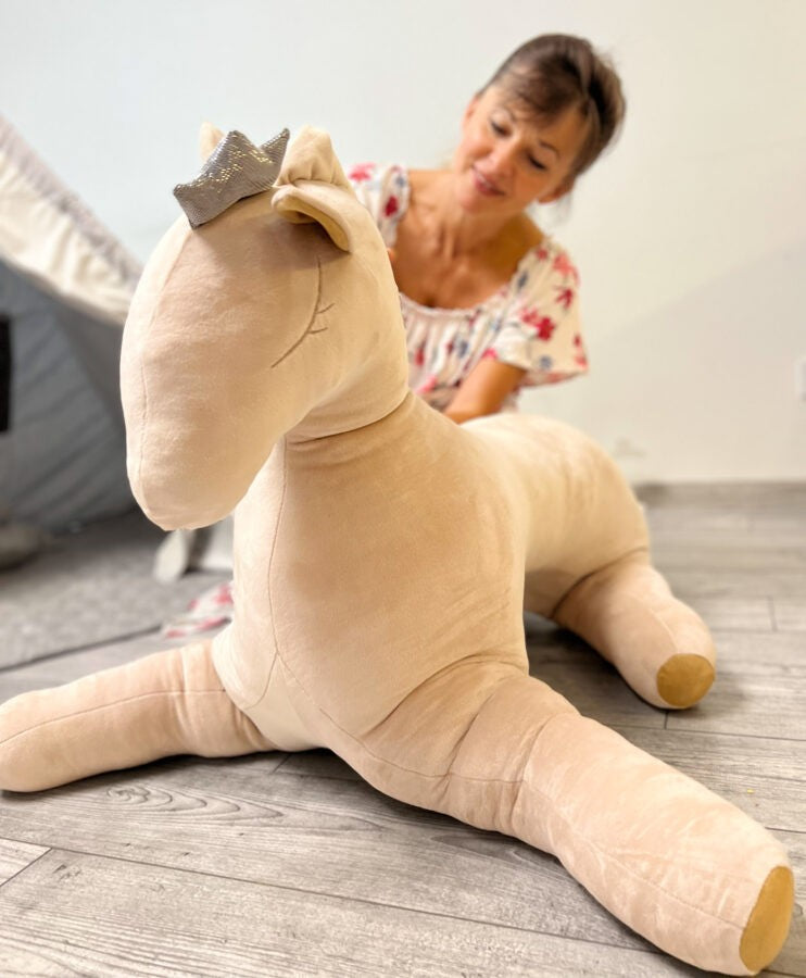 a soft cream velvet pegasus plush toy with a gentle crown, bathed in warm nursery light
