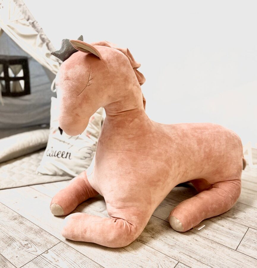 a close-up detail shot of the giant velvet pegasus toy, showcasing its soft dusty pink fabric and durable stitching for everyday play