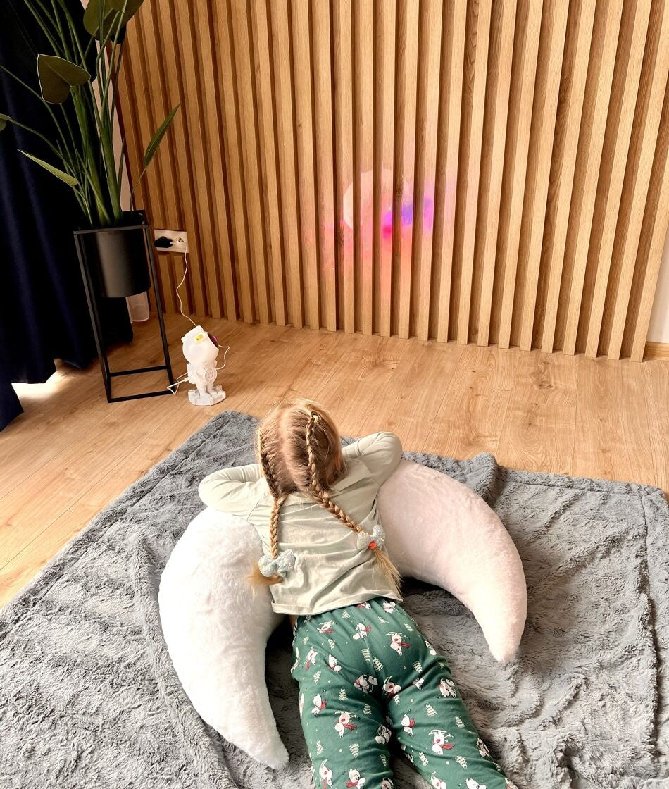 a plush crescent moon pillow with soft faux fur, shown in warm morning light