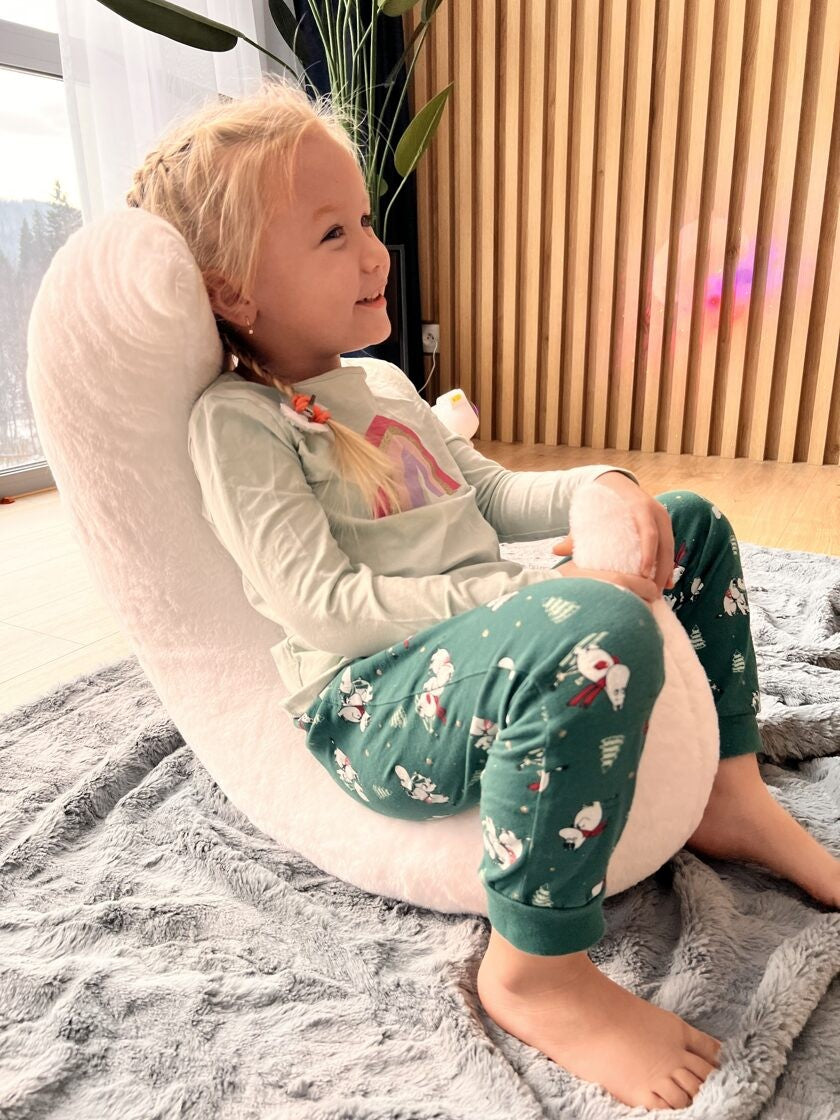 an elegant crescent moon pillow with plush faux fur, artfully lit in a minimalist nursery