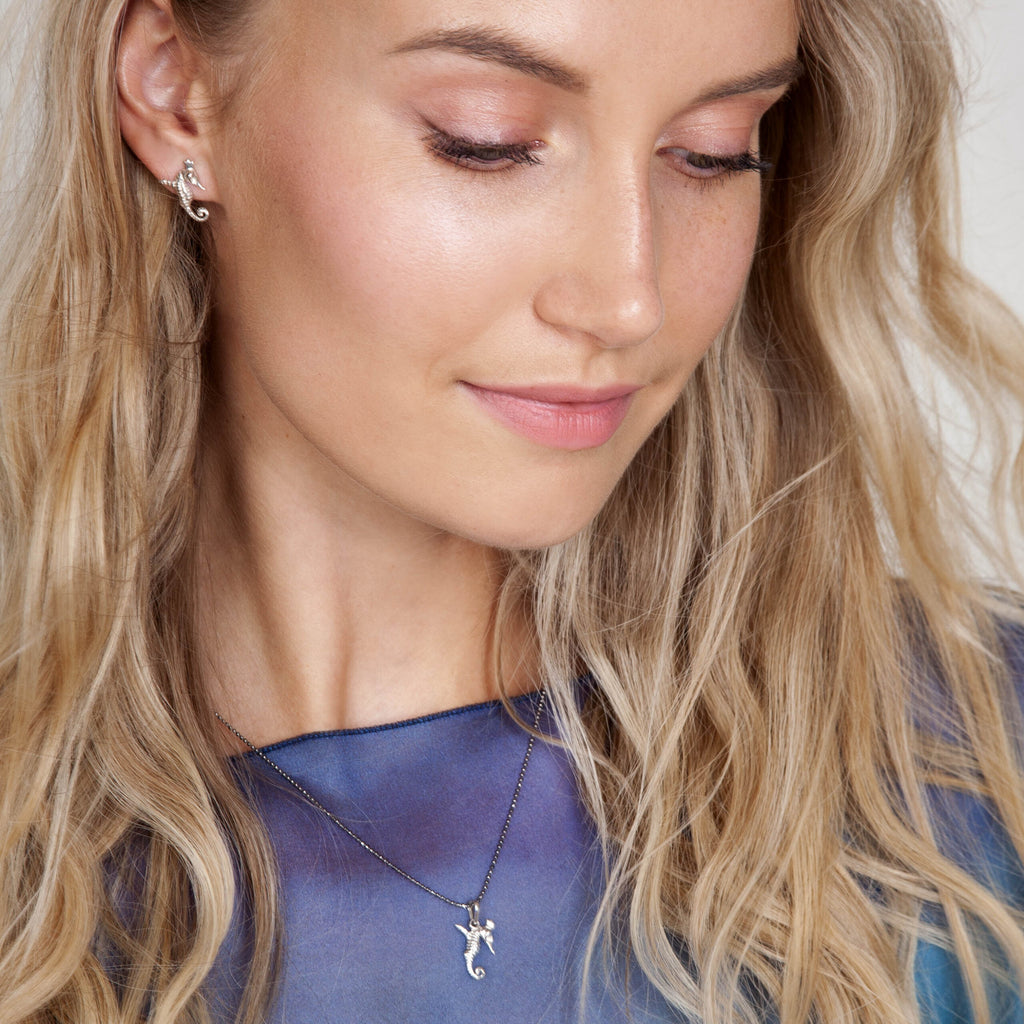 soft rose gold seahorse earrings glowing in warm light, a delicate and comforting gift