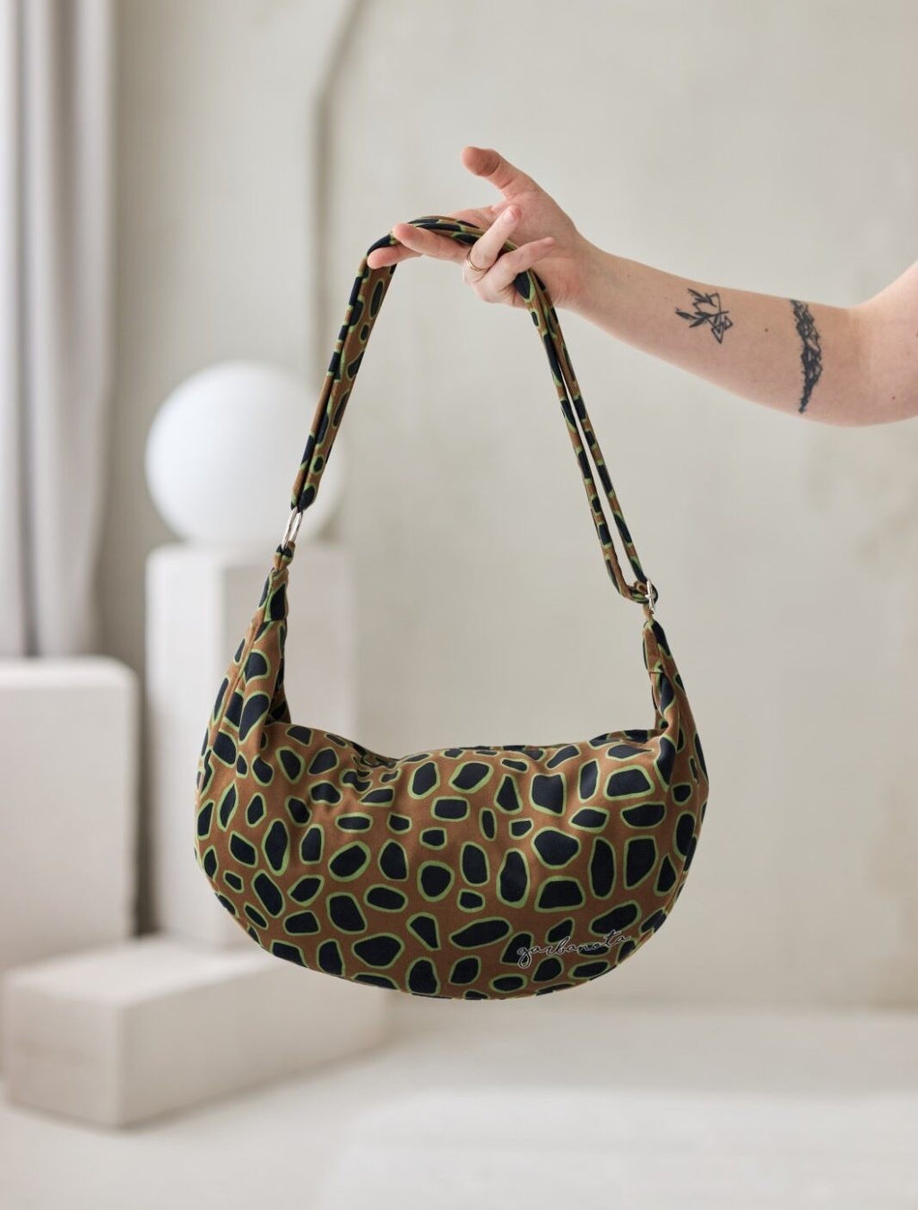 confident woman carrying a bold curly leopard print hobo bag against a city backdrop