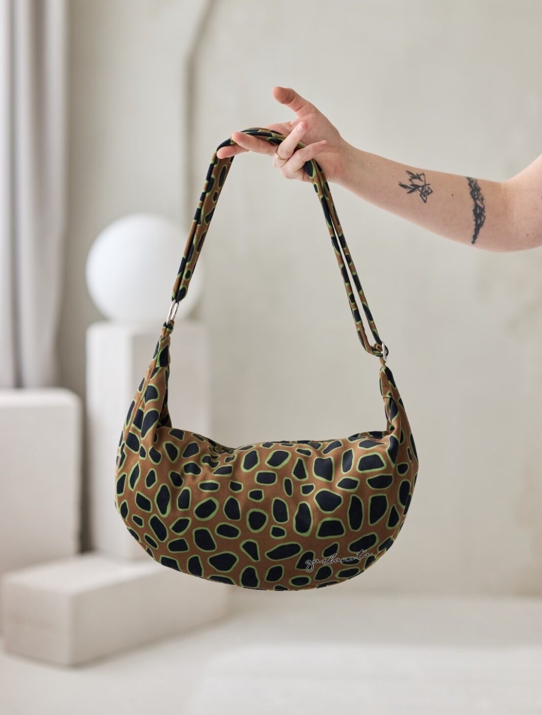 confident woman carrying a bold curly leopard print hobo bag against a city backdrop