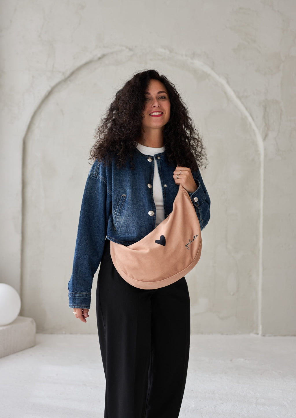 bold close-up of a stylish cream velour hobo bag with its adjustable strap