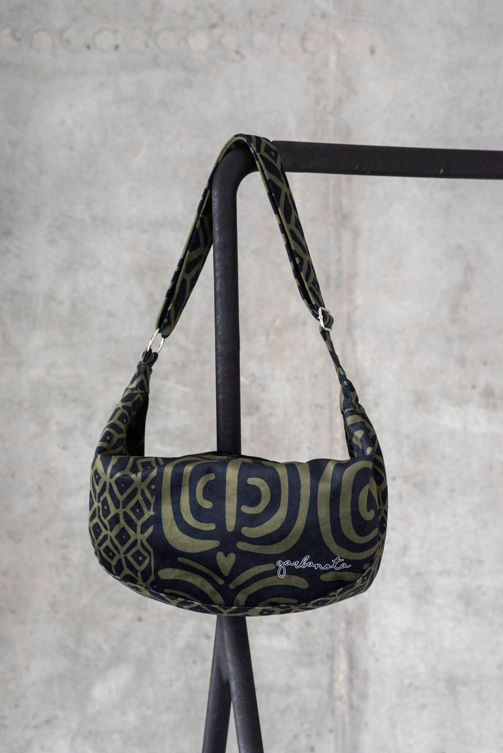 playful woman swinging a stylish khaki velour hobo bag on a sunny day