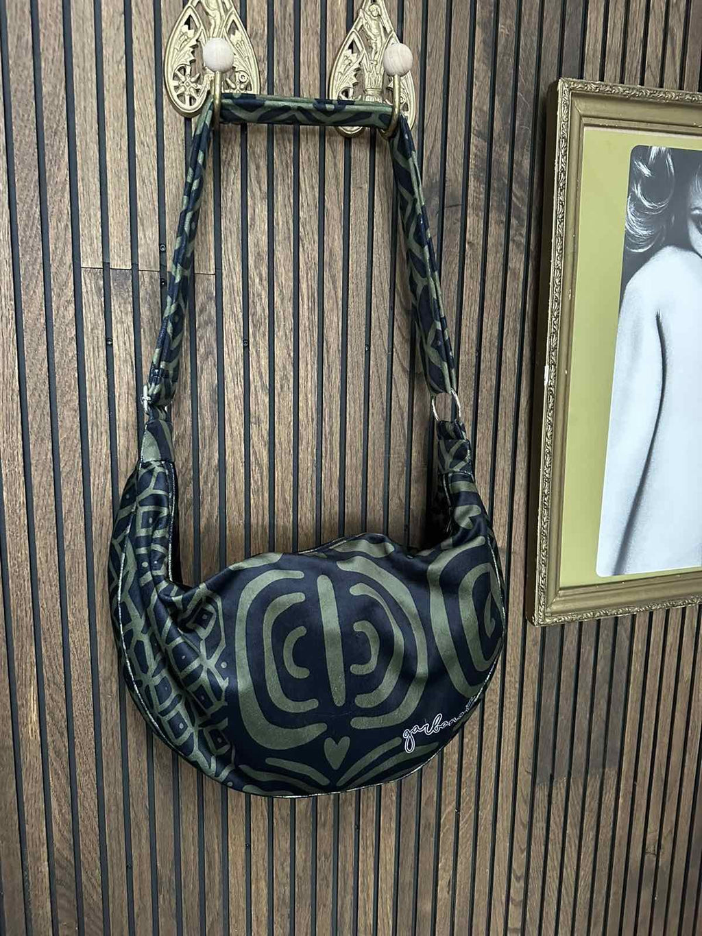 confident woman modeling a stylish khaki velour hobo bag with an adjustable shoulder strap
