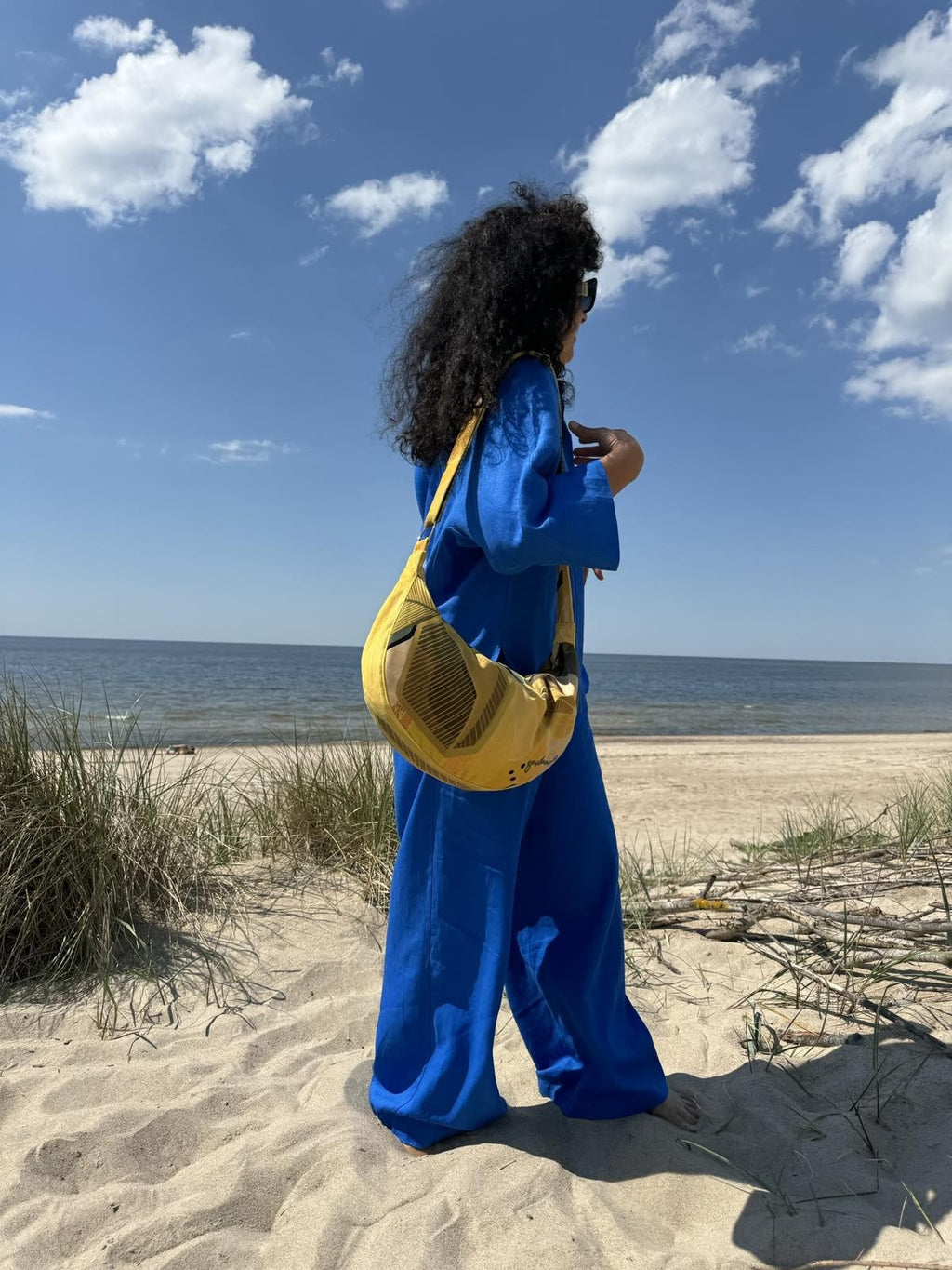 playful lemon yellow velour hobo bag slung over a shoulder in golden hour light