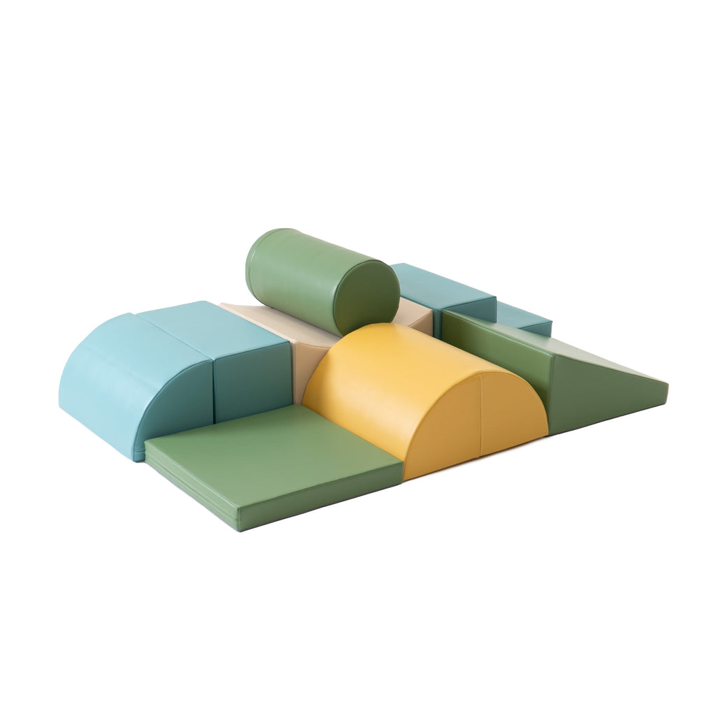 a child's hand reaching for a pastel turquoise iglu foam block on a soft rug