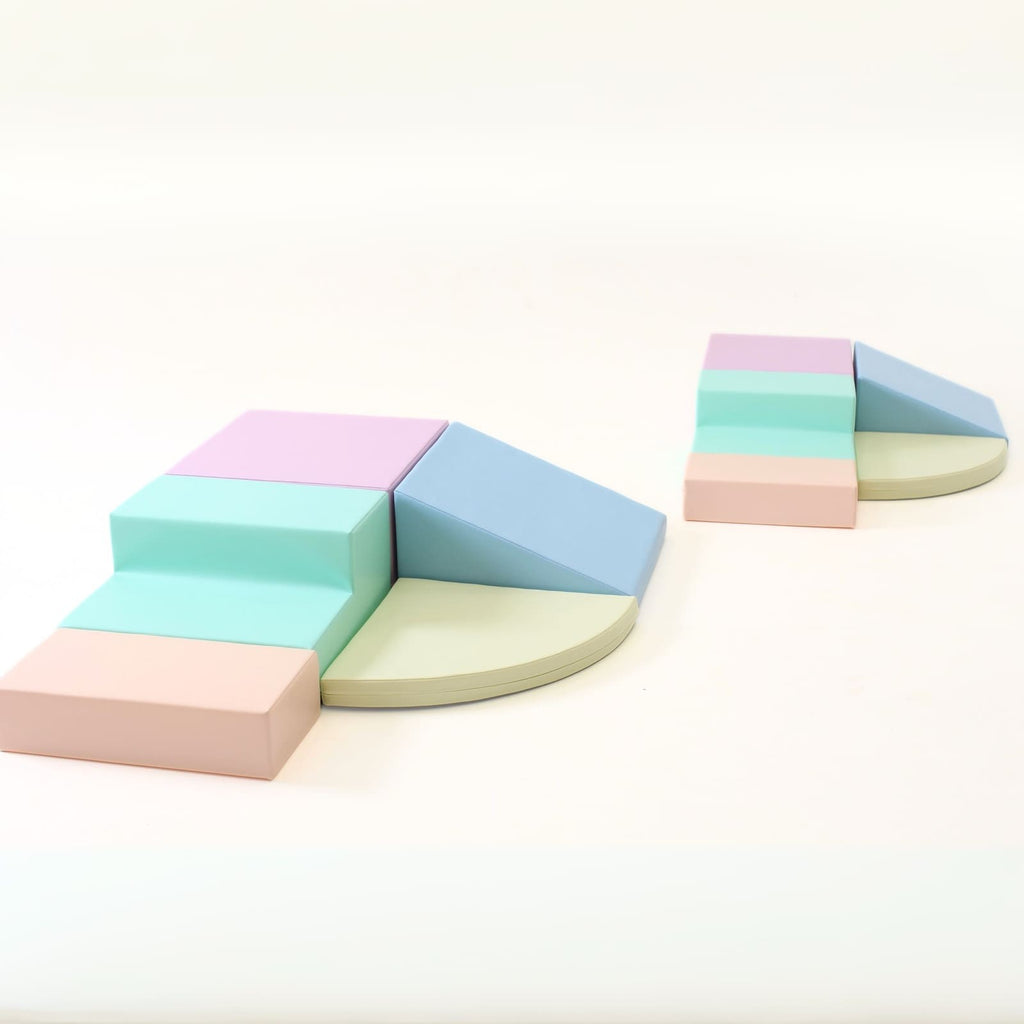a child's hand reaching for a pastel foam climber block in a sunlit playroom